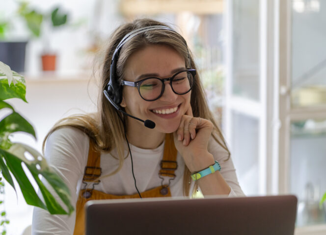 Smiling gardener millennial woman wear headphones talk video cal